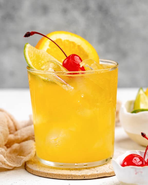 Copycat Applebee's white peach sangria garnished with orange, lime, and a cherry.