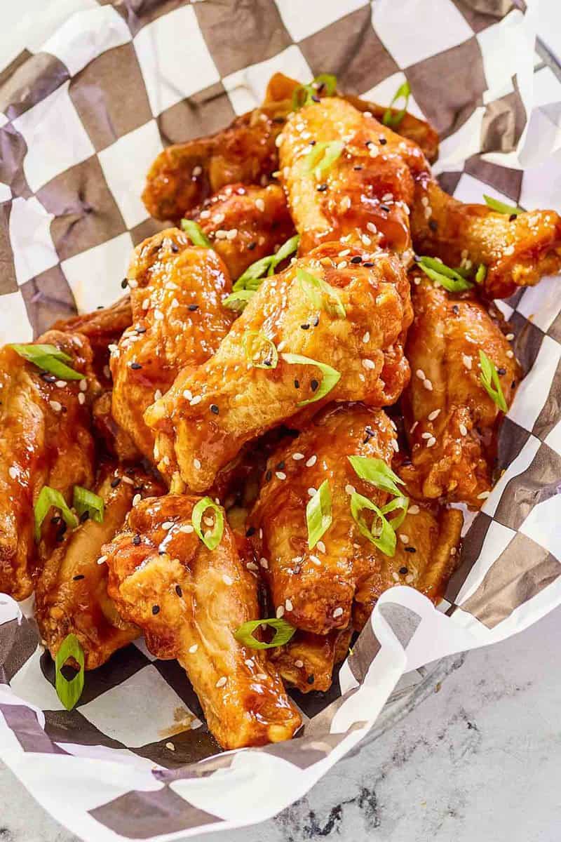 Copycat Buffalo Wild Wings General Tso chicken wings in a basket lined with parchment paper.