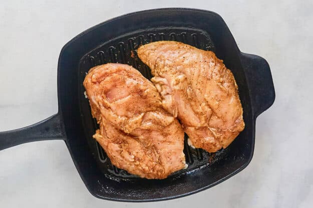 Marinated chicken breasts in a grill pan.