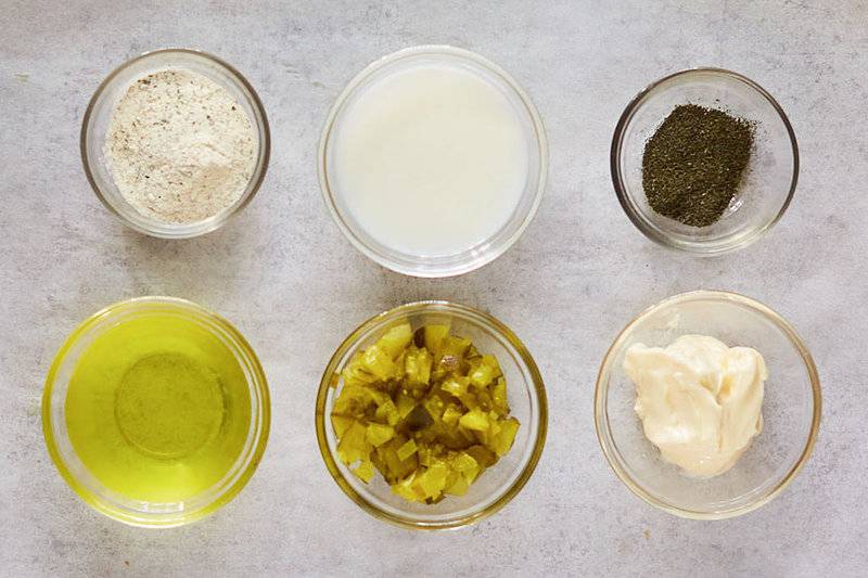 Dill pickle ranch dressing ingredients in small glass bowls.