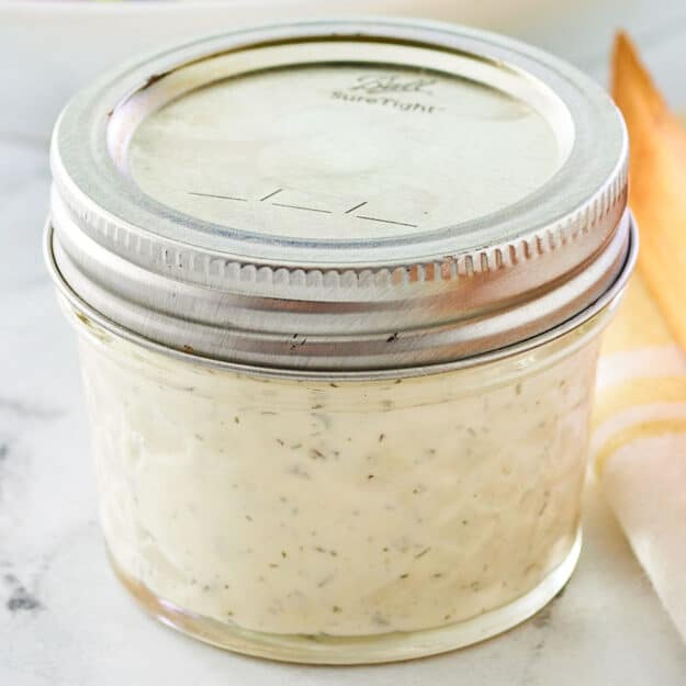 Dill pickle ranch dressing in a mason jar with a lid on it.