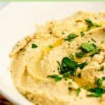 Homemade garlic hummus topped with fresh parsley and olive oil.