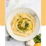Overhead view of garlic hummus in a bowl.