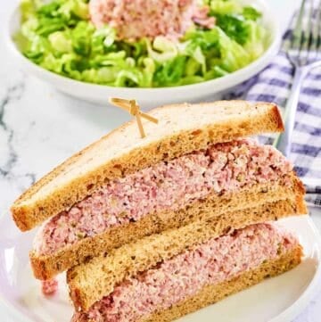 Ham salad sandwich and a scoop of ham salad on lettuce in a bowl.