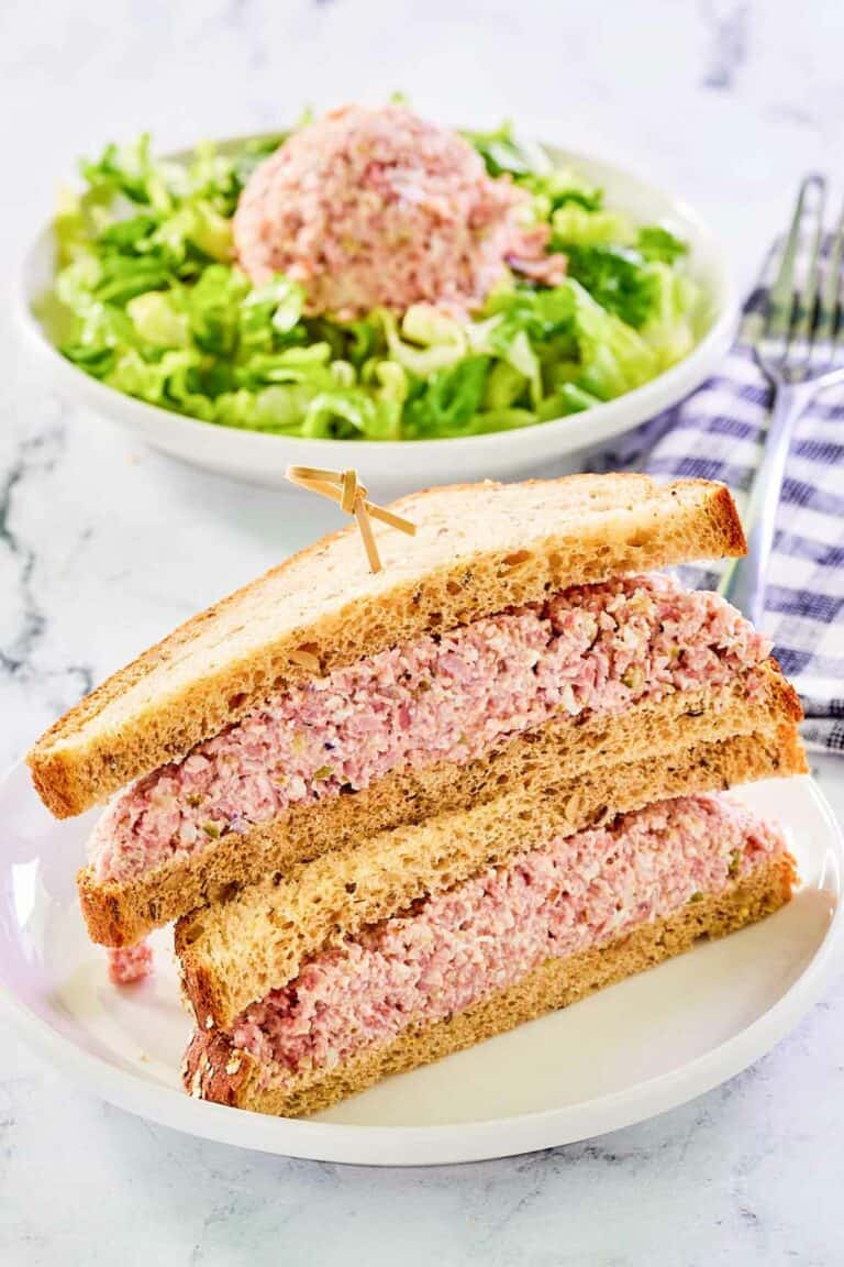 Ham salad sandwich and a scoop of ham salad on lettuce in a bowl.