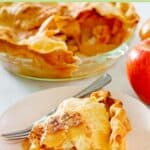 A slice of old fashioned apple pie, apples, and the pie in a glass pie dish.