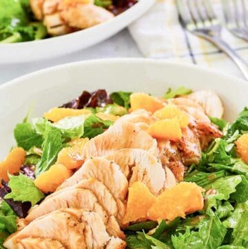 Copycat TGI Friday's mandarin orange salad with chicken in a white bowl.