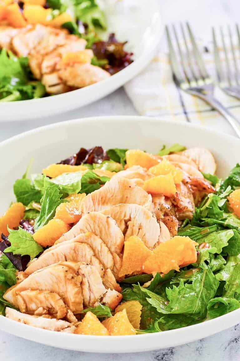 Copycat TGI Friday's mandarin orange salad with chicken in a white bowl.