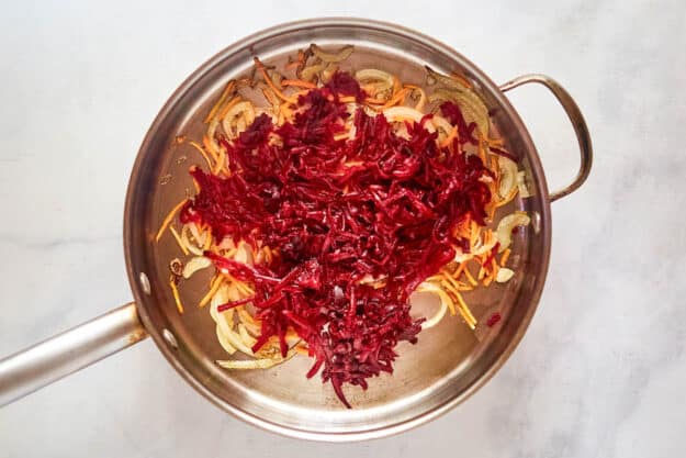 Shredded beets and vegetables in a pot.