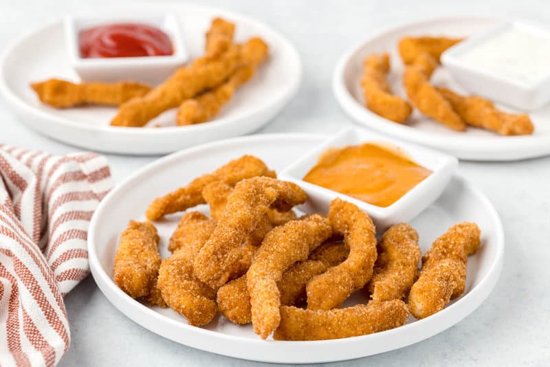 Copycat Burger King chicken fries and dipping sauces on plates.