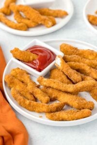 Copycat Burger King chicken fries and a small cup of ketchup on a plate.