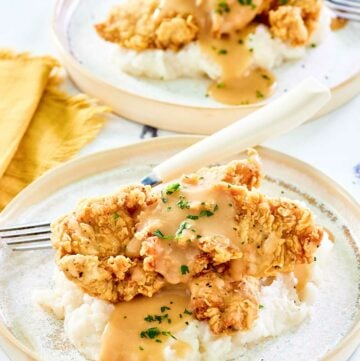 Copycat Cracker Barrel fried chicken tenders on two plates.