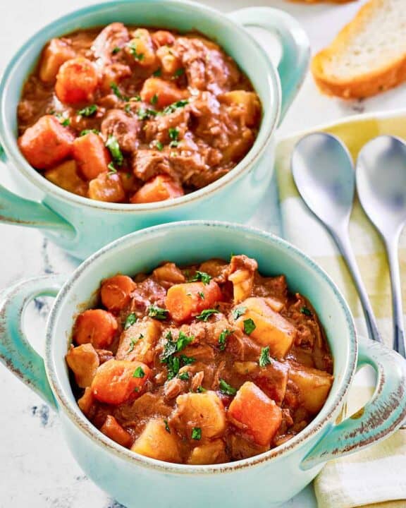 Crockpot beef stew with potatoes and carrots in two bowls.