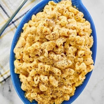 Homemade mac and cheese, a spoon, and a cloth napkin.