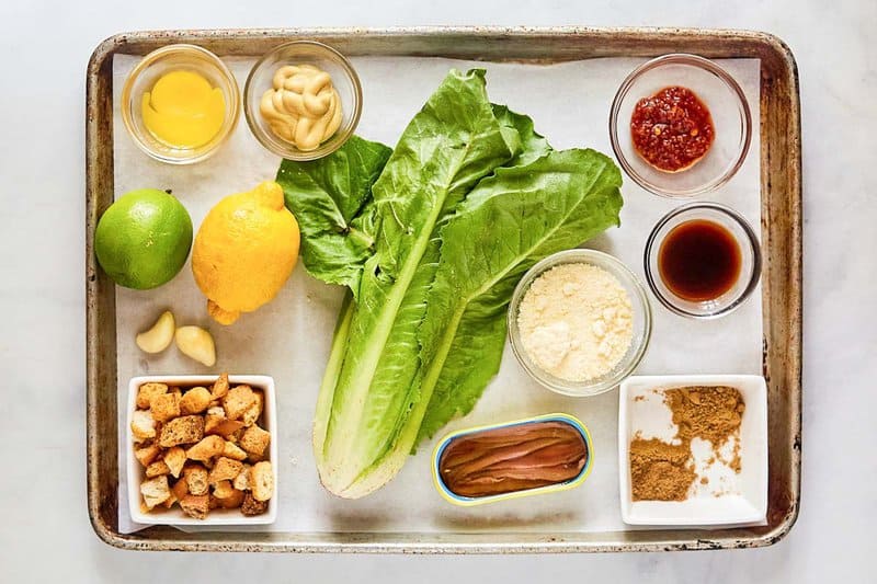 Copycat Houston's spicy Caesar dressing and salad ingredients on a tray.