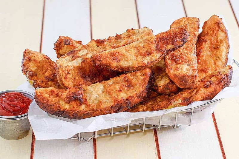 Jojo potato wedges in a wire parchment paper-lined serving basket.