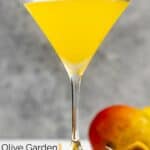 Homemade Olive Garden mango martini and a mango behind it.