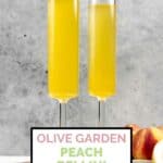 Two homemade Olive Garden peach bellini drinks on a wood tray.