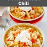 Copycat Ruby Tuesday white chicken chili garnished with cheese and sour cream.