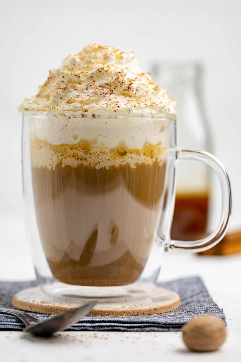 Copycat Starbucks pumpkin spice latte and pumpkin syrup behind it.