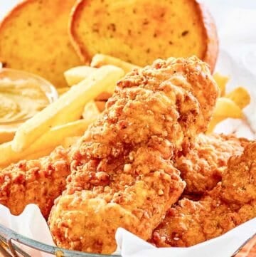 Copycat Whataburger chicken strips, fries, toast, and dipping sauce in a basket.