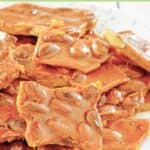 Almond brittle piled on a plate.