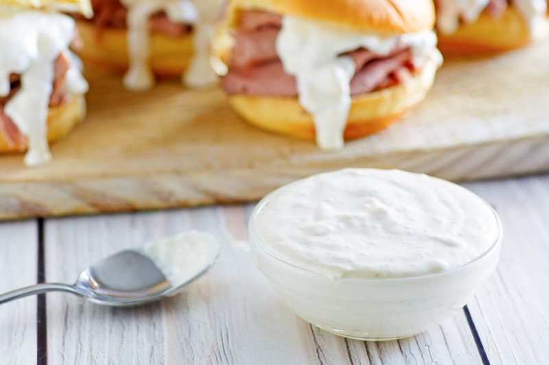 Copycat Arby's horsey sauce in a small bowl and a spoon next to it.