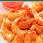 Beer battered fried shrimp and a small bowl of dipping sauce on a plate.