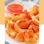 Beer battered shrimp and a small bowl of dipping sauce on a plate.
