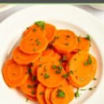 Boiled carrot slices garnished with fresh parsley on a plate.