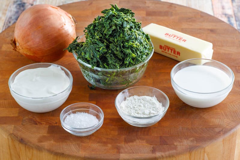 Copycat Boston Market creamed spinach ingredients on a round wood board.