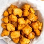 Copycat Chick Fil A chicken nuggets in a parchment paper lined basket.