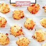 Homemade coconut macaroons scattered on a wood surface.