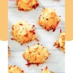Several homemade coconut macaroons on a wood surface.