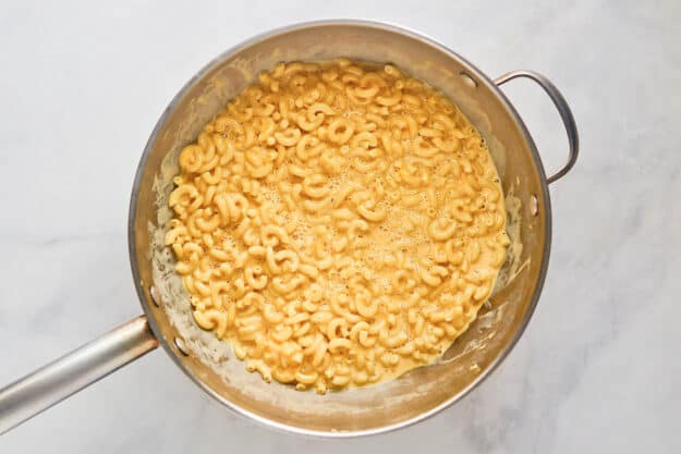 Cooking copycat Cracker Barrel mac and cheese in a pan.