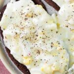 Creamed eggs on toast with black pepper on top.