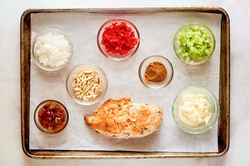 Curried chicken salad ingredients on a tray.