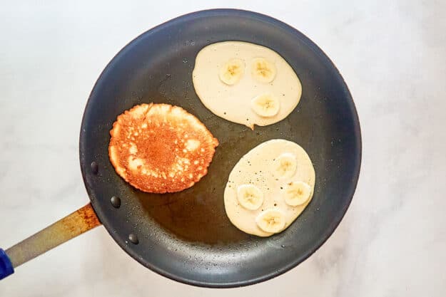 Cooking banana buttermilk pancakes in a skillet.