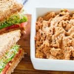 A small bowl of homemade Loma Linda sandwich spread next to a sandwich.