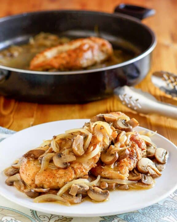 Copycat Olive Garden chicken marsala on a plate and in a skillet.