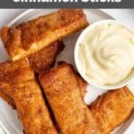 Several homemade Pizza Hut cinnamon sticks and a bowl of cream cheese icing for dipping.