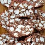 Pieces of homemade rocky road candy piled on a wood board.