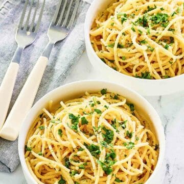 Two bowls of copycat Spaghetti Warehouse spaghetti with garlic butter.
