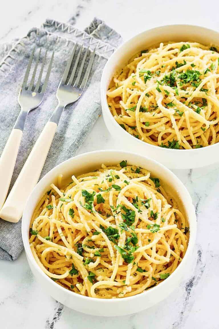 Two bowls of copycat Spaghetti Warehouse spaghetti with garlic butter.