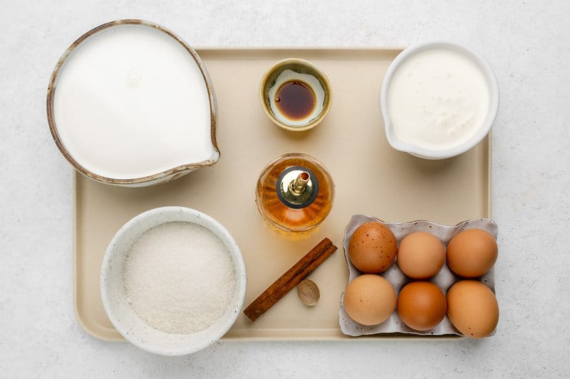 Homemade spiked eggnog ingredients on a tray.