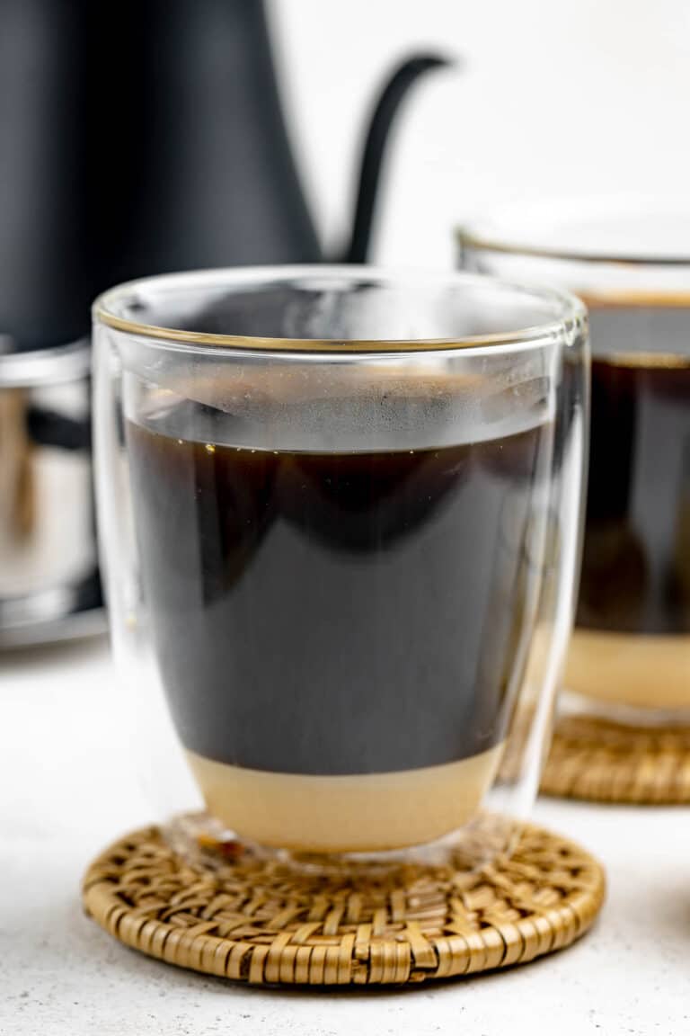 Vietnamese coffee in a mug on top of a coaster.