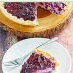 Blueberry cream cheese pie on a round wood board and a slice on a plate.