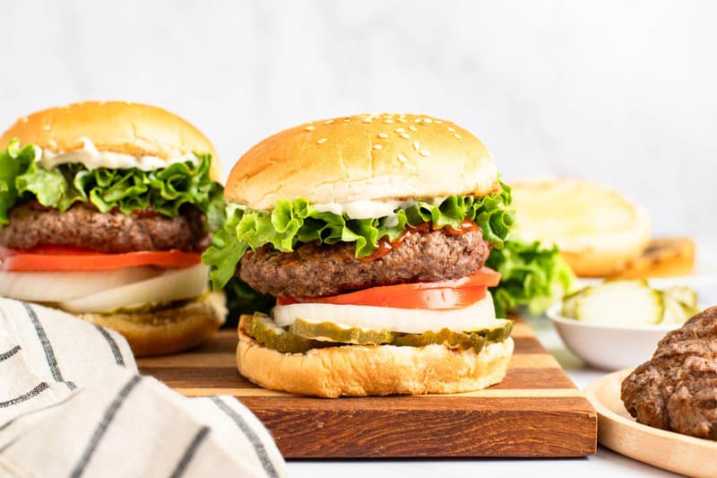 Two copycat Burger King Whopper sandwiches on a wood board.