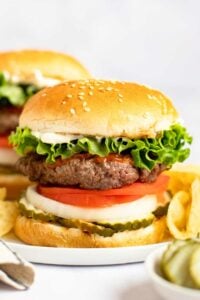 Copycat Burger King Whopper and potato chips on a plate.