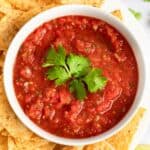 A vessel  of copycat Chili's salsa and tortilla chips connected  a platter.